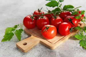 Fresh red cherry tomatoes on vine and cutting board, a Food & Drink Photo by Olena Rudo