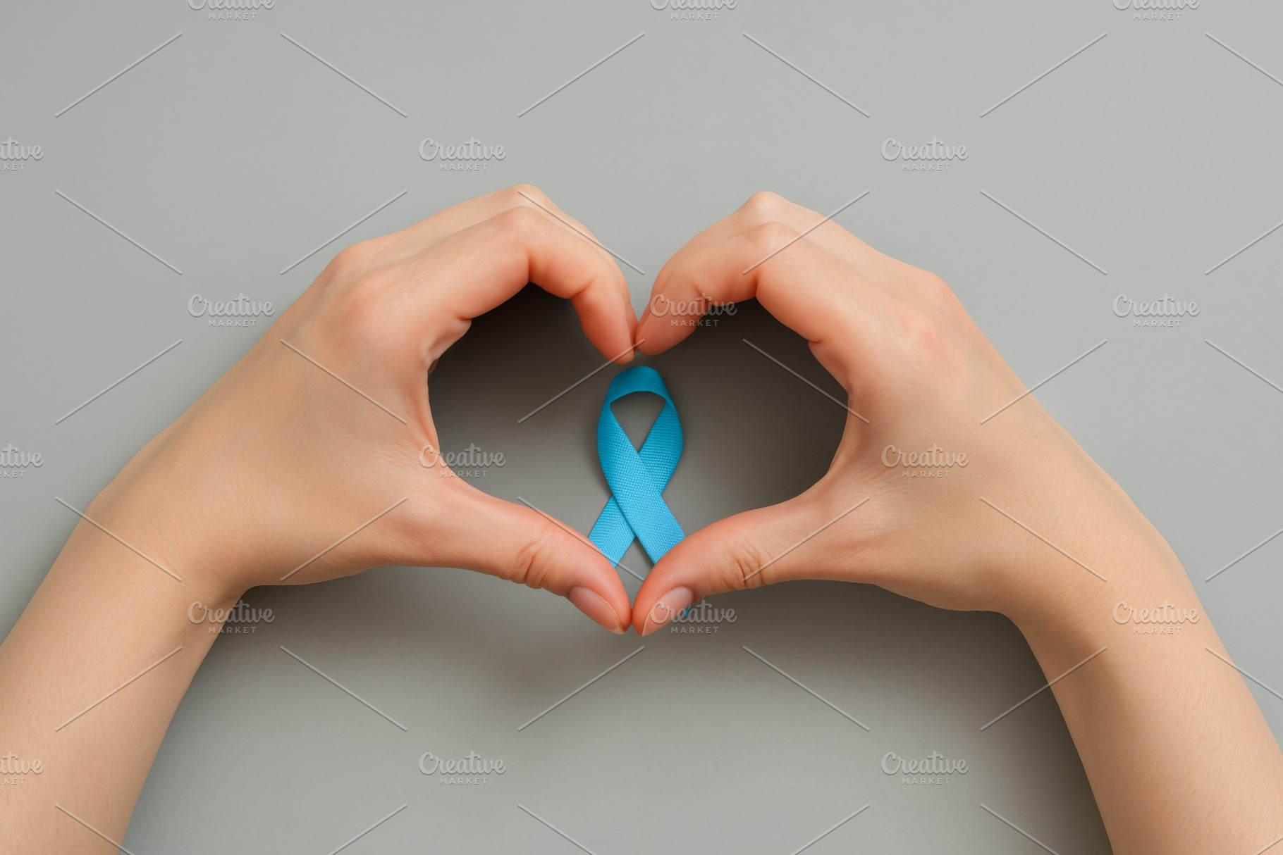 Men health awareness ribbon between hands symbolizing mens healt, a Photo by Dvoevnore photos