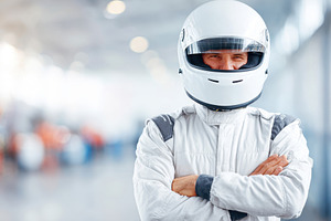 Confident race car driver in helmet and suit, a Sports & Recreation Photo by AlyaAnd