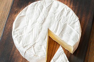 Creamy Camembert Cheese Wheel With Slice Removed On Rustic Woode, a Food & Drink Photo by Alexander Prokopenko