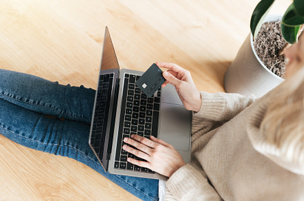 Young woman holding credit card and using laptop computer., a Business Photo by Olena Rudo