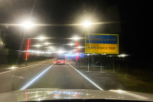Night drive to the border with bright street lights and a welcoming have a nice, a Photo by AS photostudio