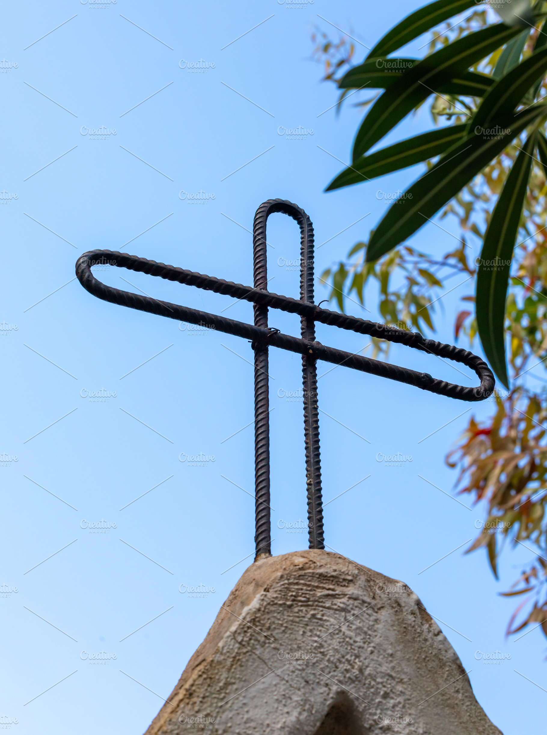 Cross made of reinforcing steel bars standing on a stone, a Photo by Antonio Gravante Market