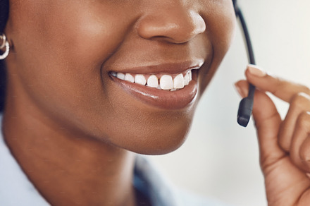 Smile, call center and mouth of black woman with headphone microphone for telemarketing, communication and customer support. Consultant, receptionist or customer service employee on phone call, a Photo by Peopleimages.com