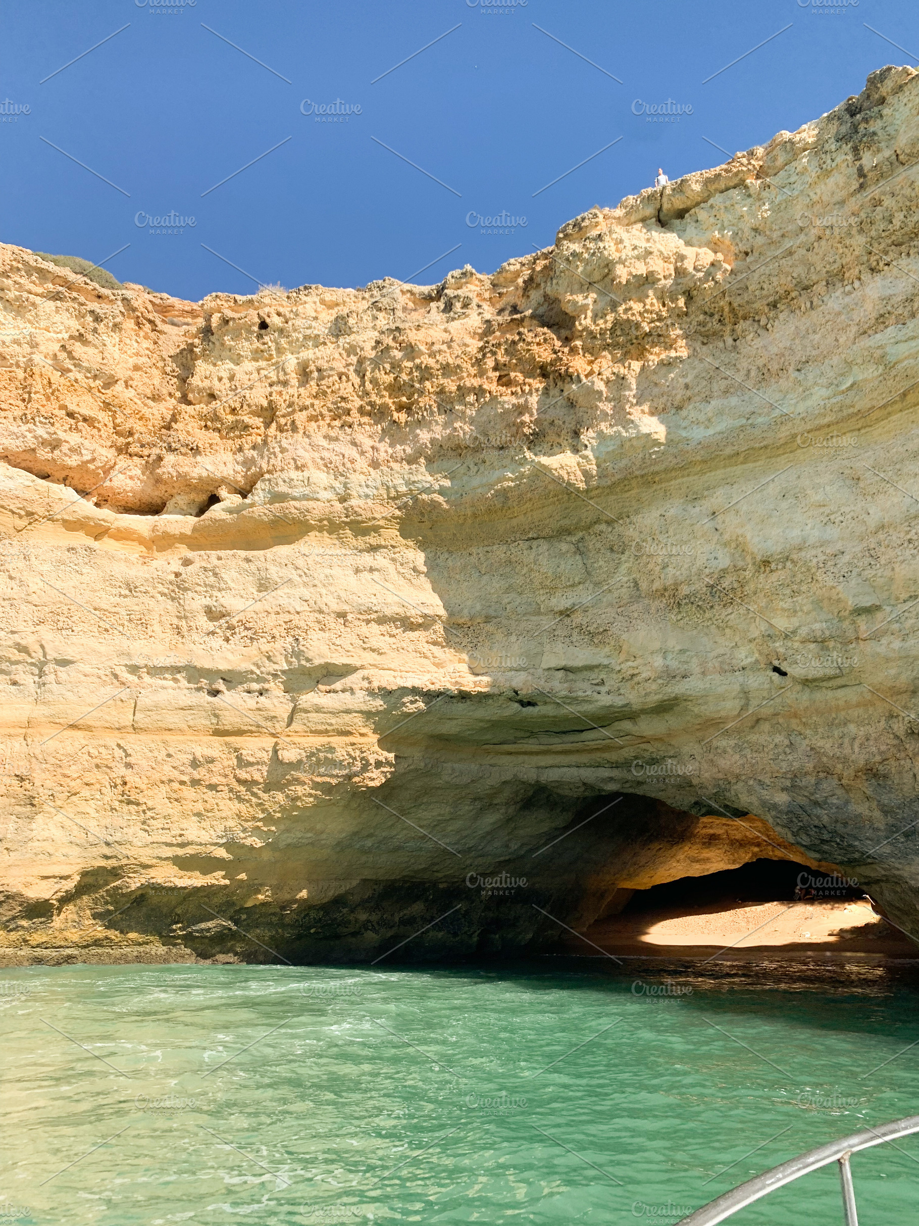 Algarve coastal cave with turquoise water and sunlight illuminat, a Holiday Photo by sebastianaraw