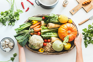 Hands holding tray with vegetables