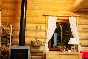 Cozy log cabin with a wood-burning stove and rustic wooden furniture, a Photo by AS photostudio