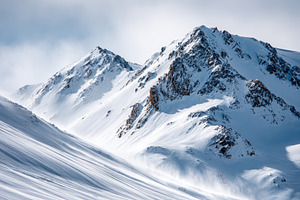 Majestic snow-covered mountains under a blue sky, a Nature Photo by AlyaAnd