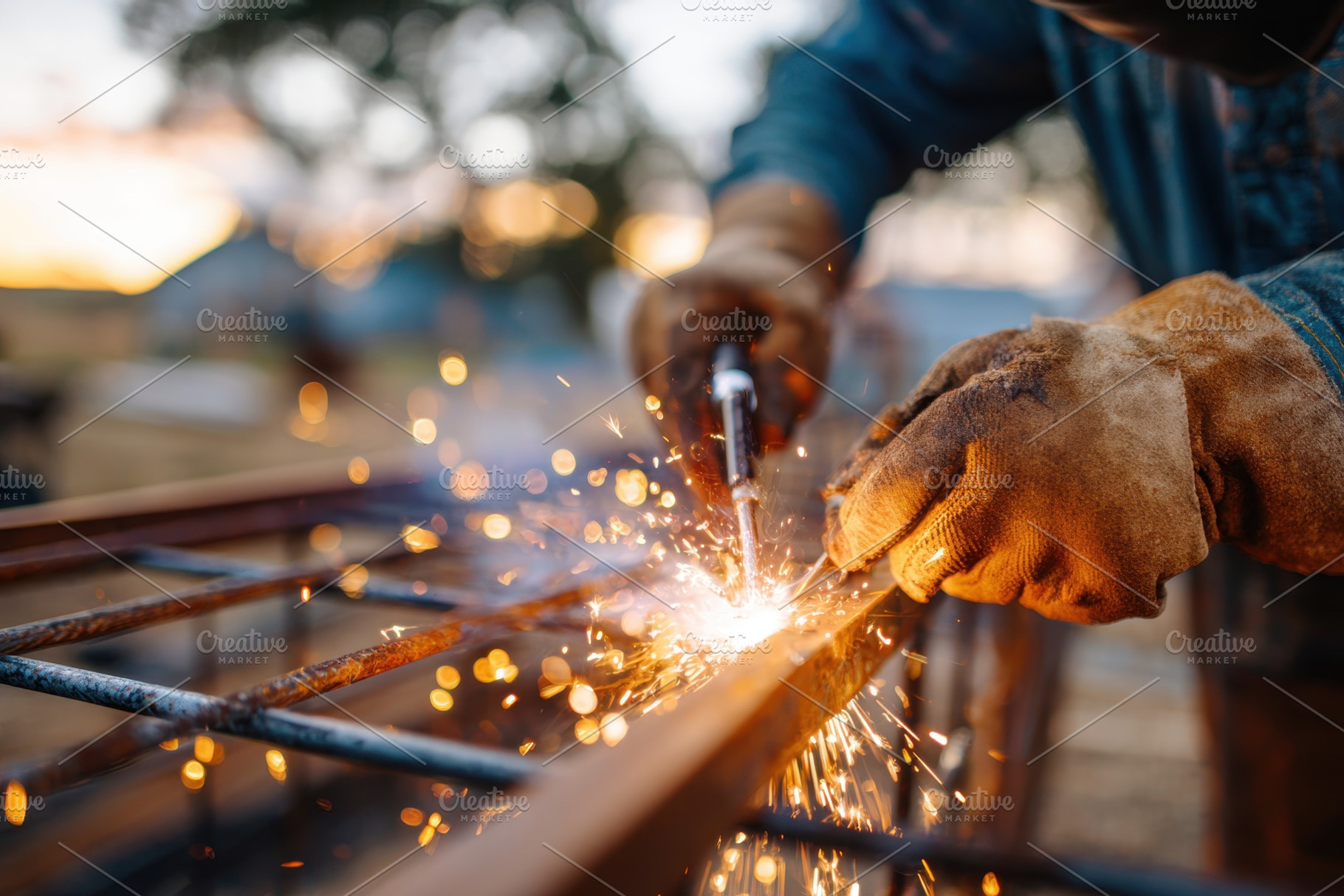 Worker welding metal rebar at sunset, an Industrial Photo by AlyaAnd