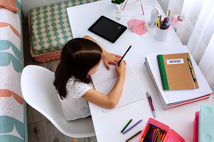 Girl studying at home with tablet and mask on table, a School & Education Photo by davidpereiras