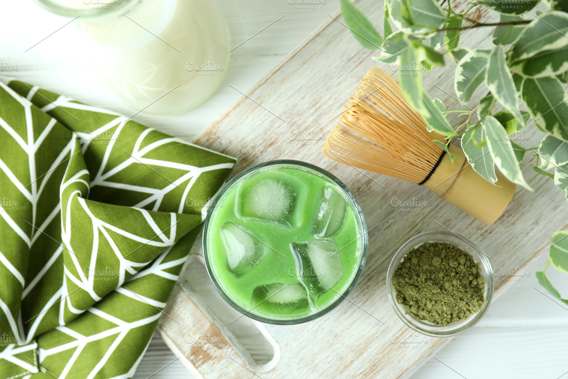 Matcha latte and accessories for making on white wooden table, a Food & Drink Photo by AtlasStudio PRO