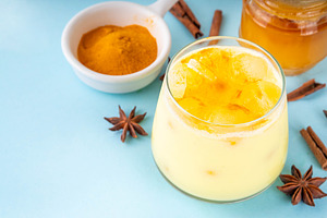 Iced golden milk drink, turmeric latte with ice cubes, a Food & Drink Photo by Rimma