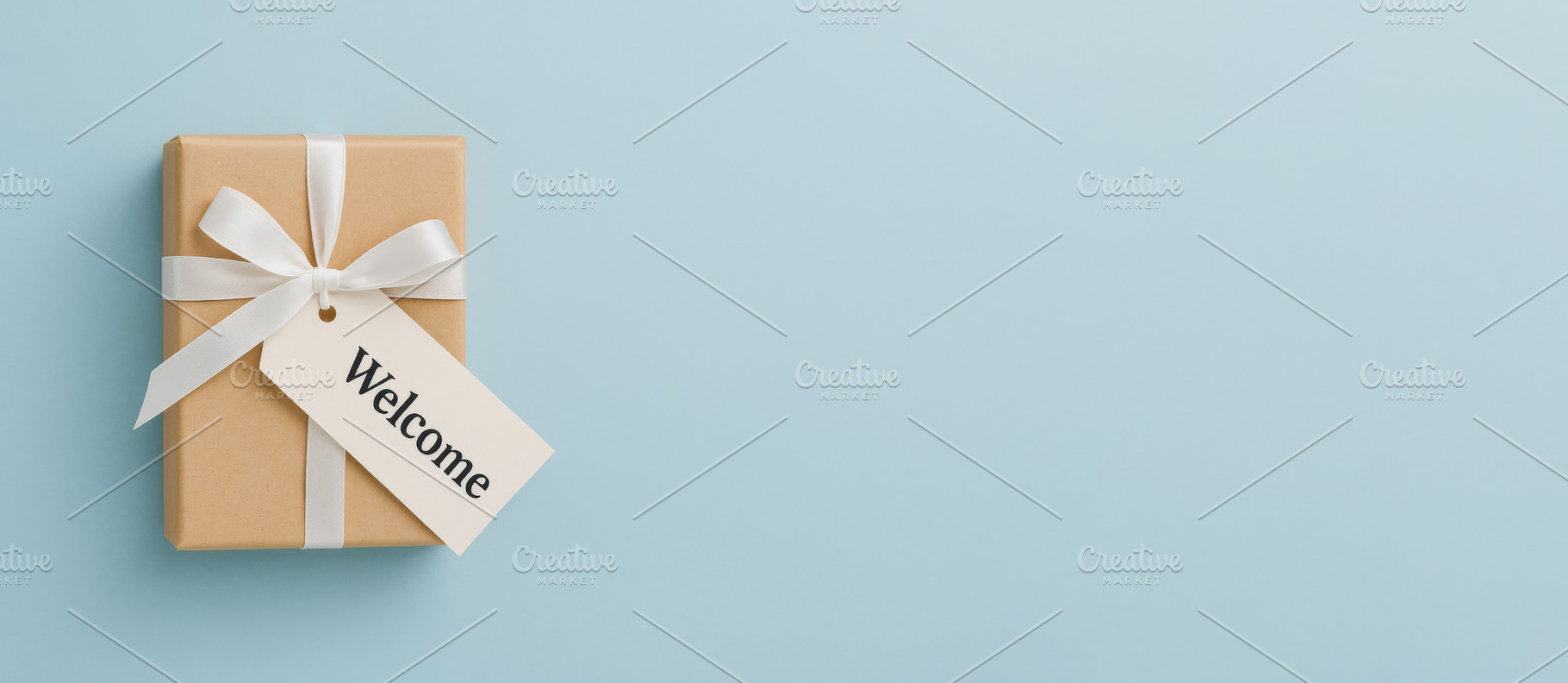 Gift box with welcome tag on light b, a Photo by Dvoevnore photos