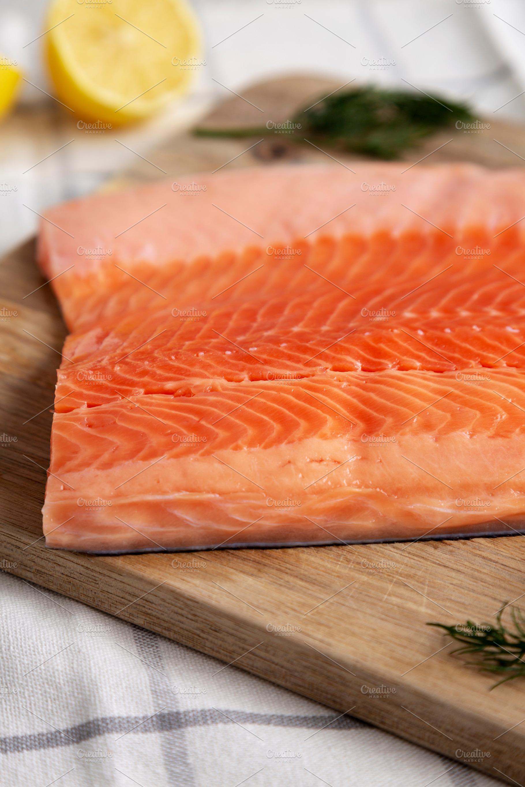 Organic Raw Salmon Fillet on a wooden board, side view., a Food & Drink Photo by LiudmylaChuhunova