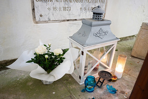 Serene commemoration with floral arrangement and candlelit lantern in memorial, a Photo by AS photostudio