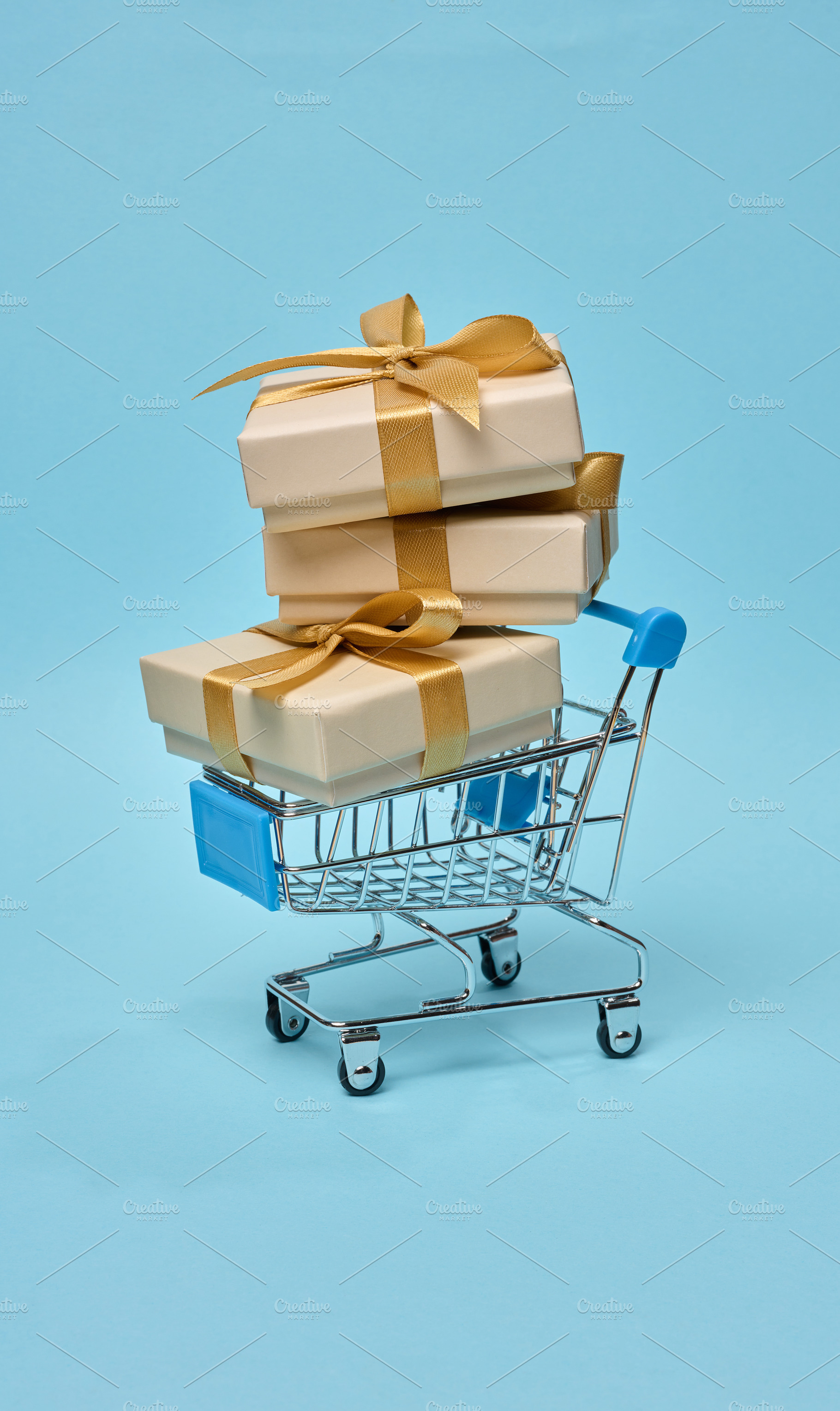Miniature shopping cart with stack of gift boxes, beige packagin, a Holiday Photo by ndanko