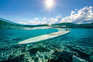 A white surfboard buoyantly floats o, a Photo by Iftikhar Alam