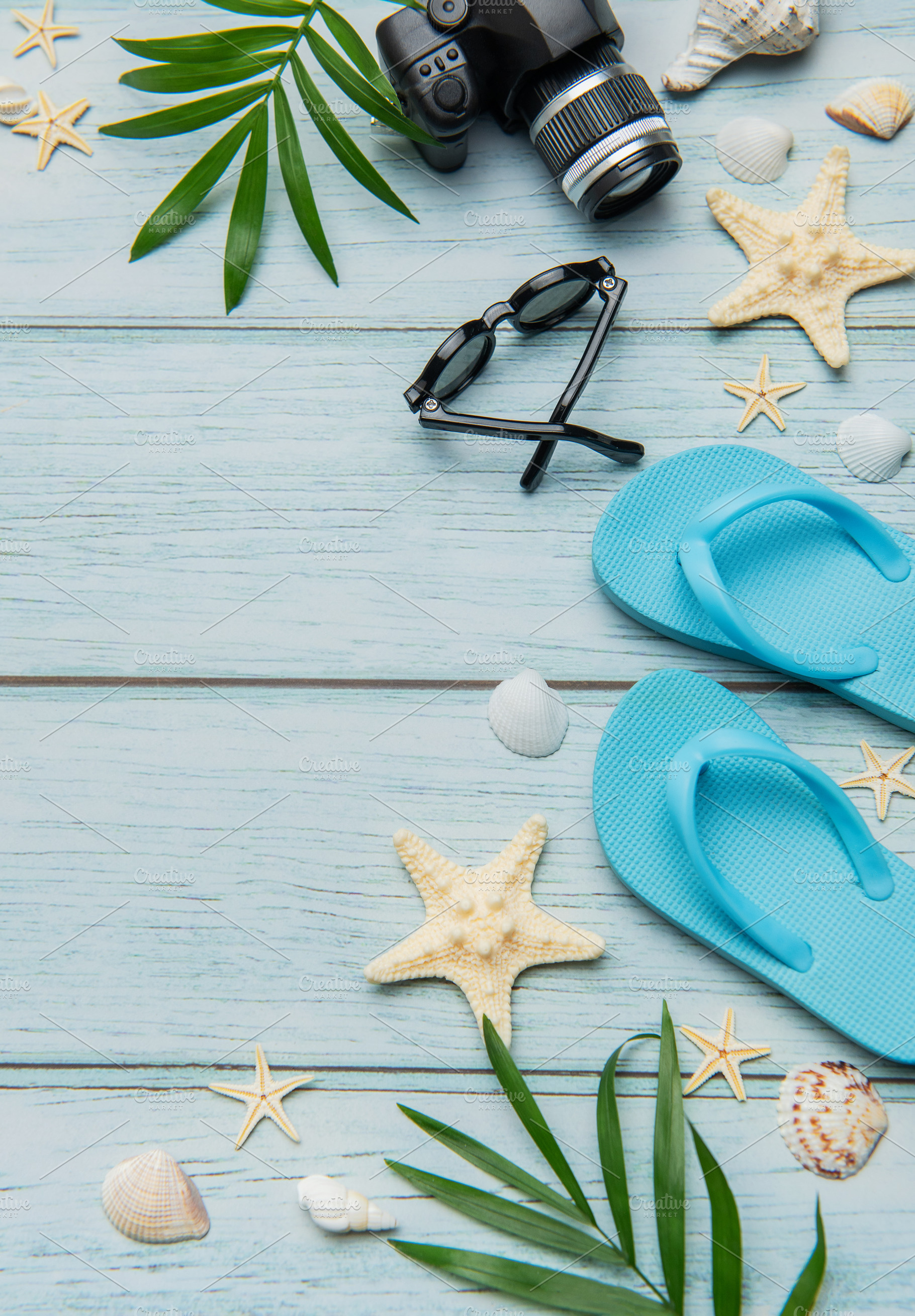 Beach vacation accessories arranged on rustic blue wooden backgr, a Holiday Photo by Olena Rudo