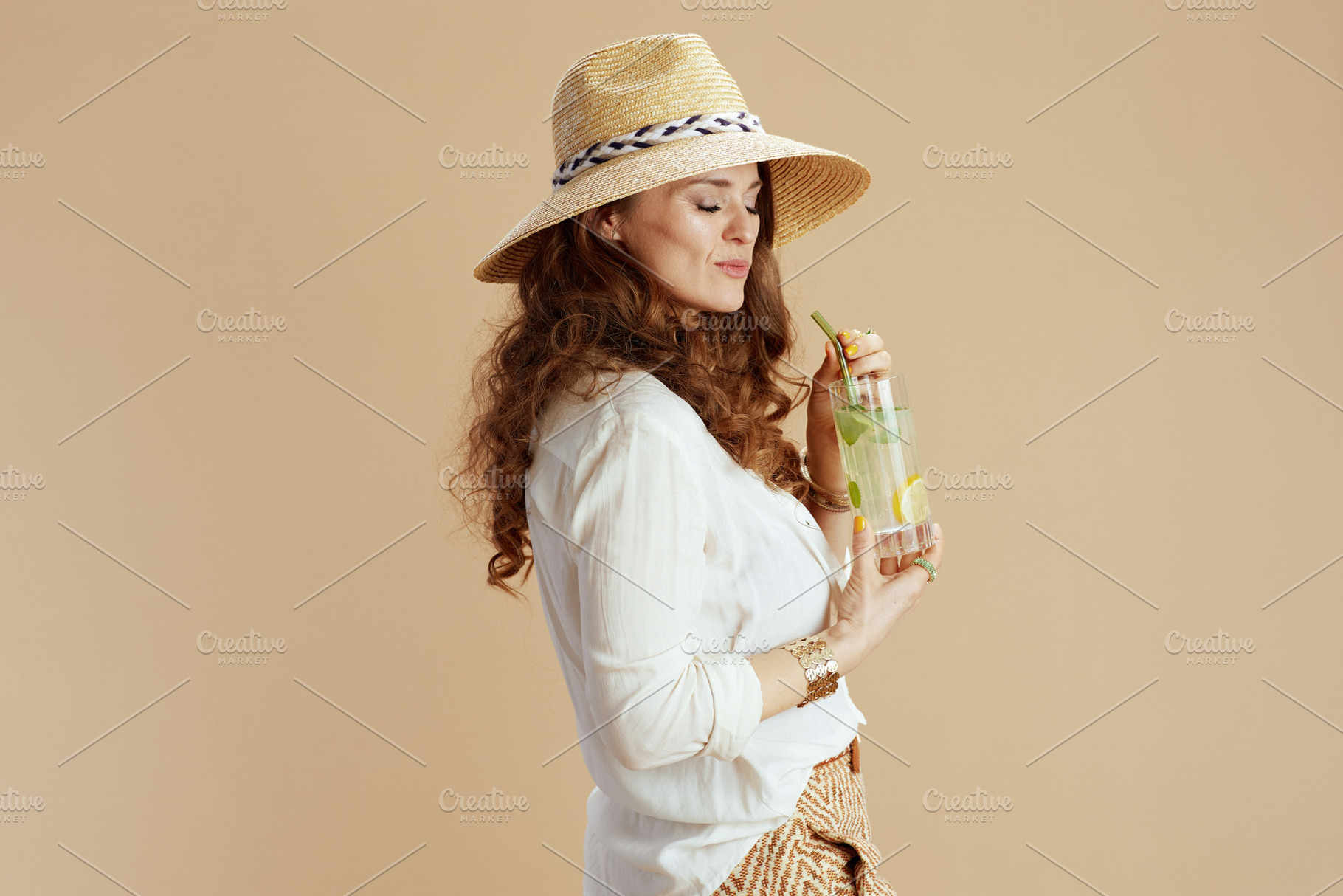 smiling housewife in blouse and shorts against beige, a Person Photo by Alliance Images