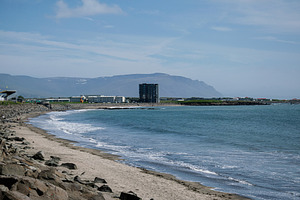 Coastal view of Akranes, Iceland, with mountains and sandy beach shoreline, a Photo by AS photostudio