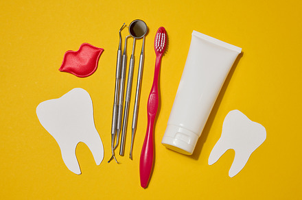 Red toothbrush, white tube of toothpaste, red decorative lips, d