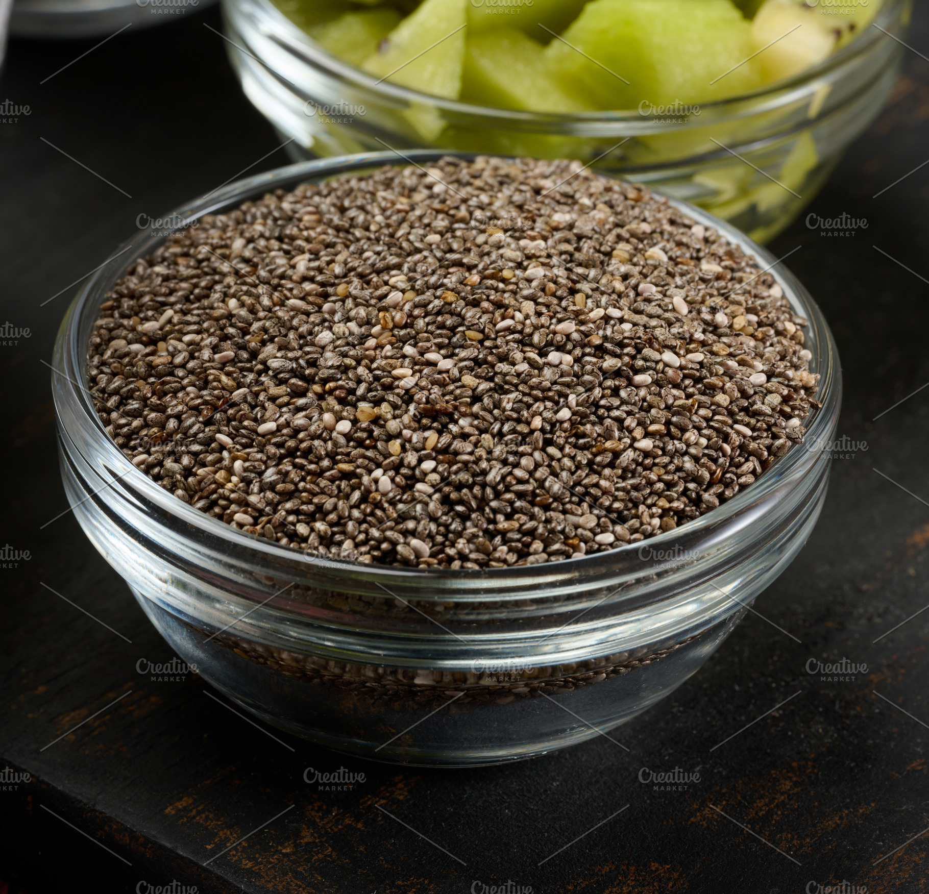 Clear glass bowl filled with dry chia seeds, top view, a Food & Drink Photo by ndanko