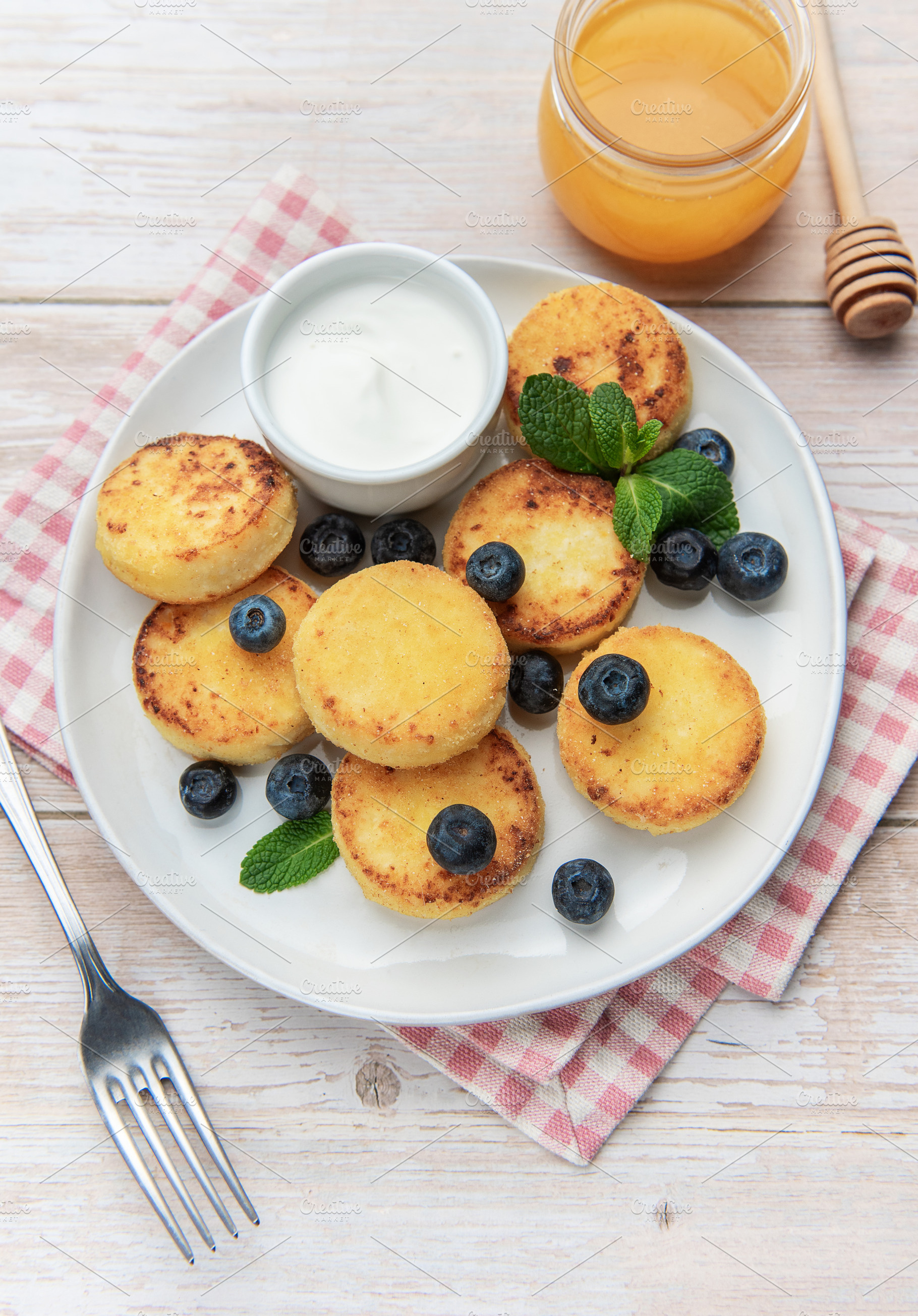 Syrniki cottage cheese pancakes with blueberries honey and sour, a Food & Drink Photo by Olena Rudo