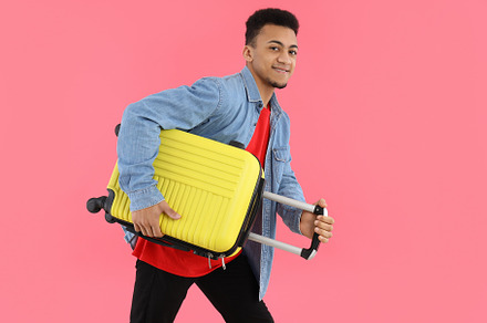 Young man with luggage bag on pink background, a Person Photo by AtlasStudio PRO