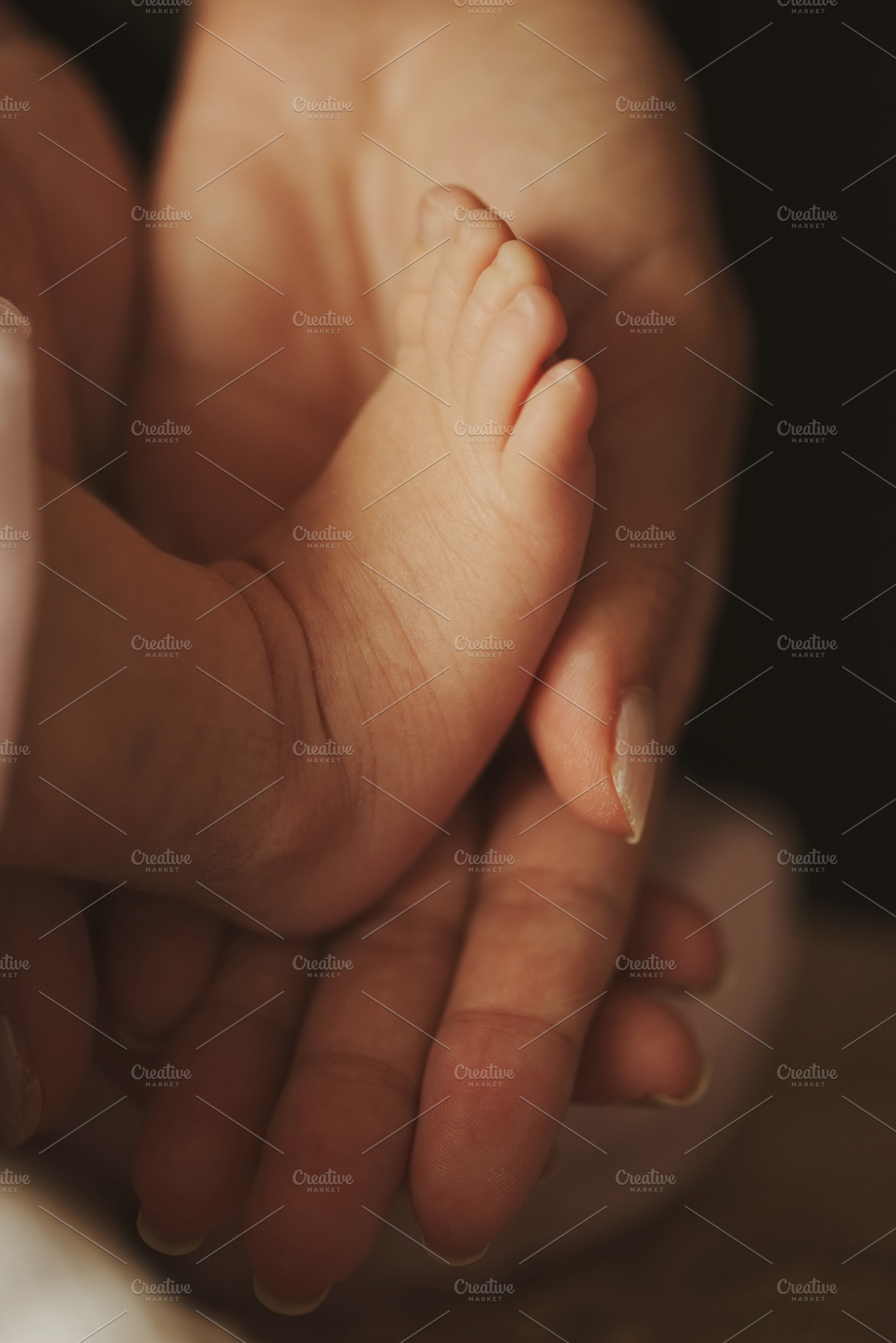 Mother holds little foot of newborn baby containing baby, mother, and feet, a Person Photo by AlohaHawaii
