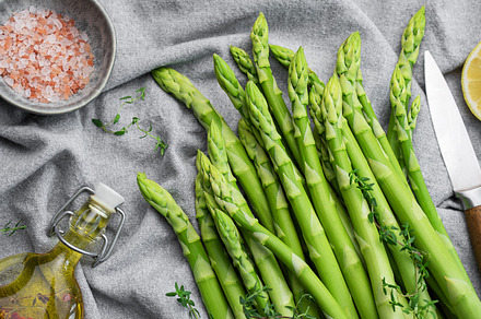 Bunch of raw asparagus stems with different spices, a Food & Drink Photo by Olena Rudo