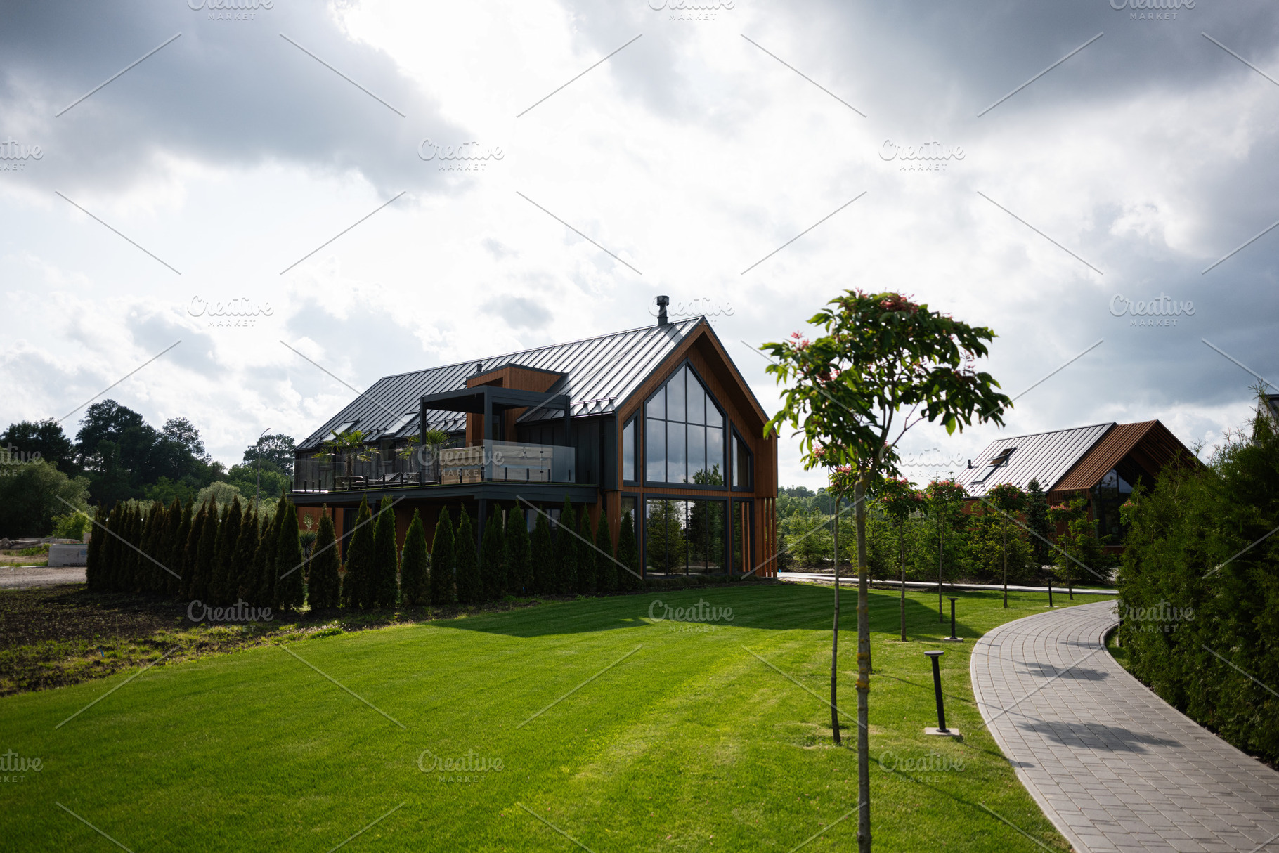 Modern wooden house surrounded by a lush green lawn and a paved pathway, a Photo by AS photostudio