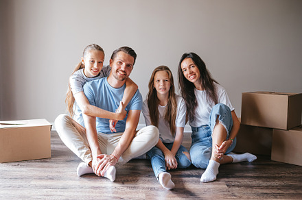 Happy family with two daughters with cardboard boxes in new house at moving day, a Person Photo by travnikovstudio