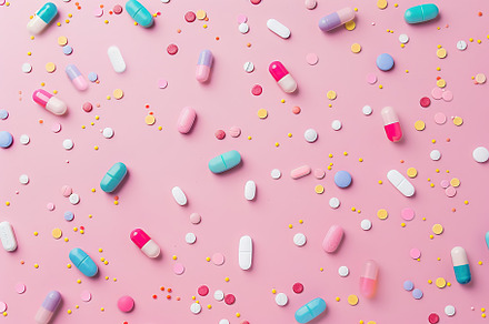 Colorful medicine pills on pink background, a Health & Medical Photo by AlyaAnd