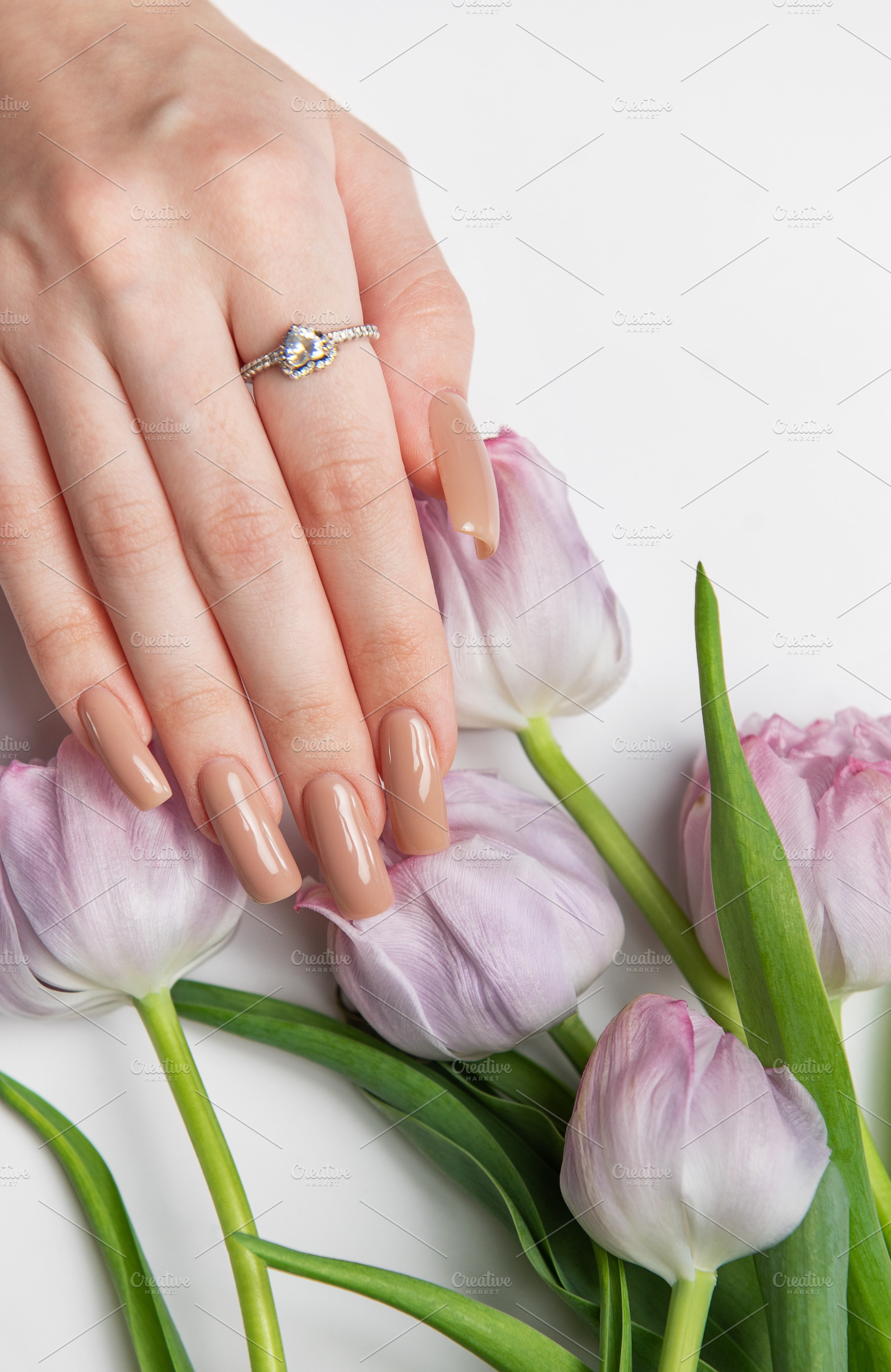 Woman showing beige manicure near bouquet of purple tulips, a Beauty & Fashion Photo by Olena Rudo
