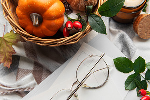 Autumn flat lay with pumpkins, candle, and warm blanket