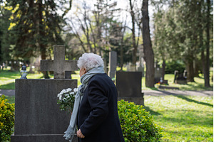 Elderly widow bringing flowers to a, a Holiday Photo by HalfPoint