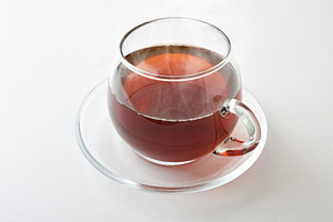 Hot infusion in a glass cup with saucer isolated, a Food & Drink Photo by Davizro's Market