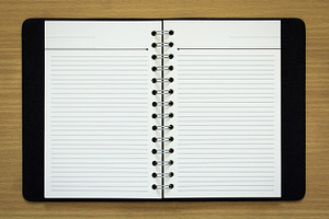 Blank spiral notebook containing notebook, paper, and white