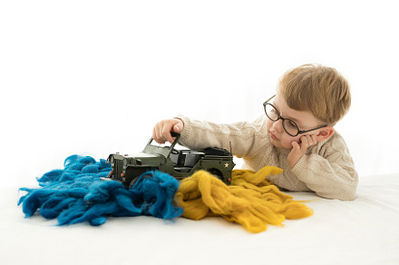 blond boy playing with a military ca