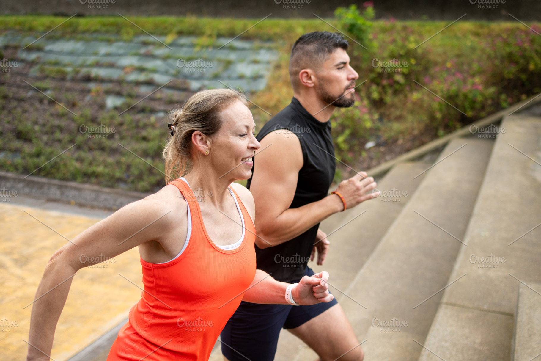 Personal trainer coaching mature woman running up stairs during outdoor workout, a Sports & Recreation Photo by etorres69