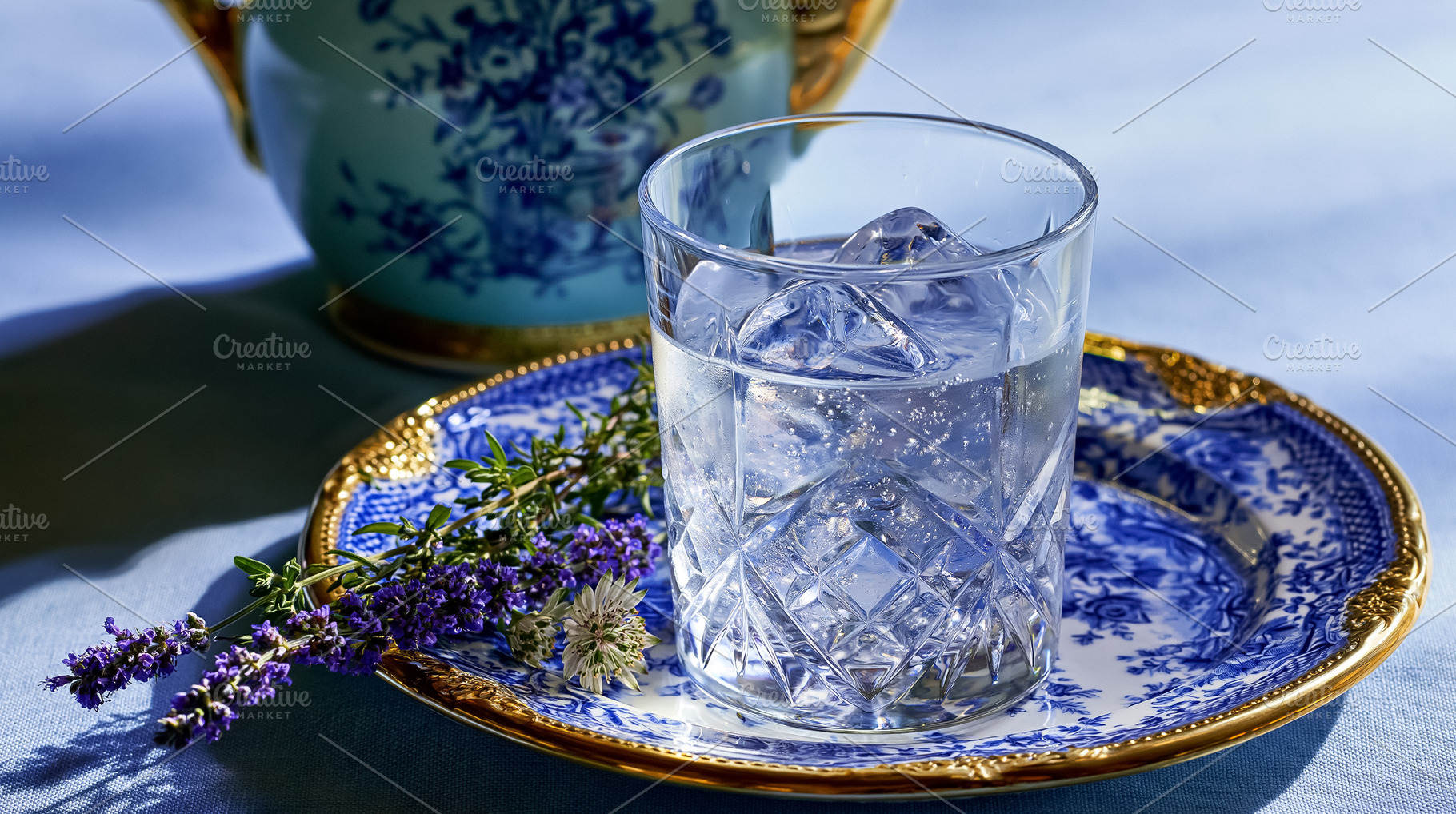 Refreshing iced water with lavender and herbs on an ornate blue and white plate, a Photo by Studio ANNA