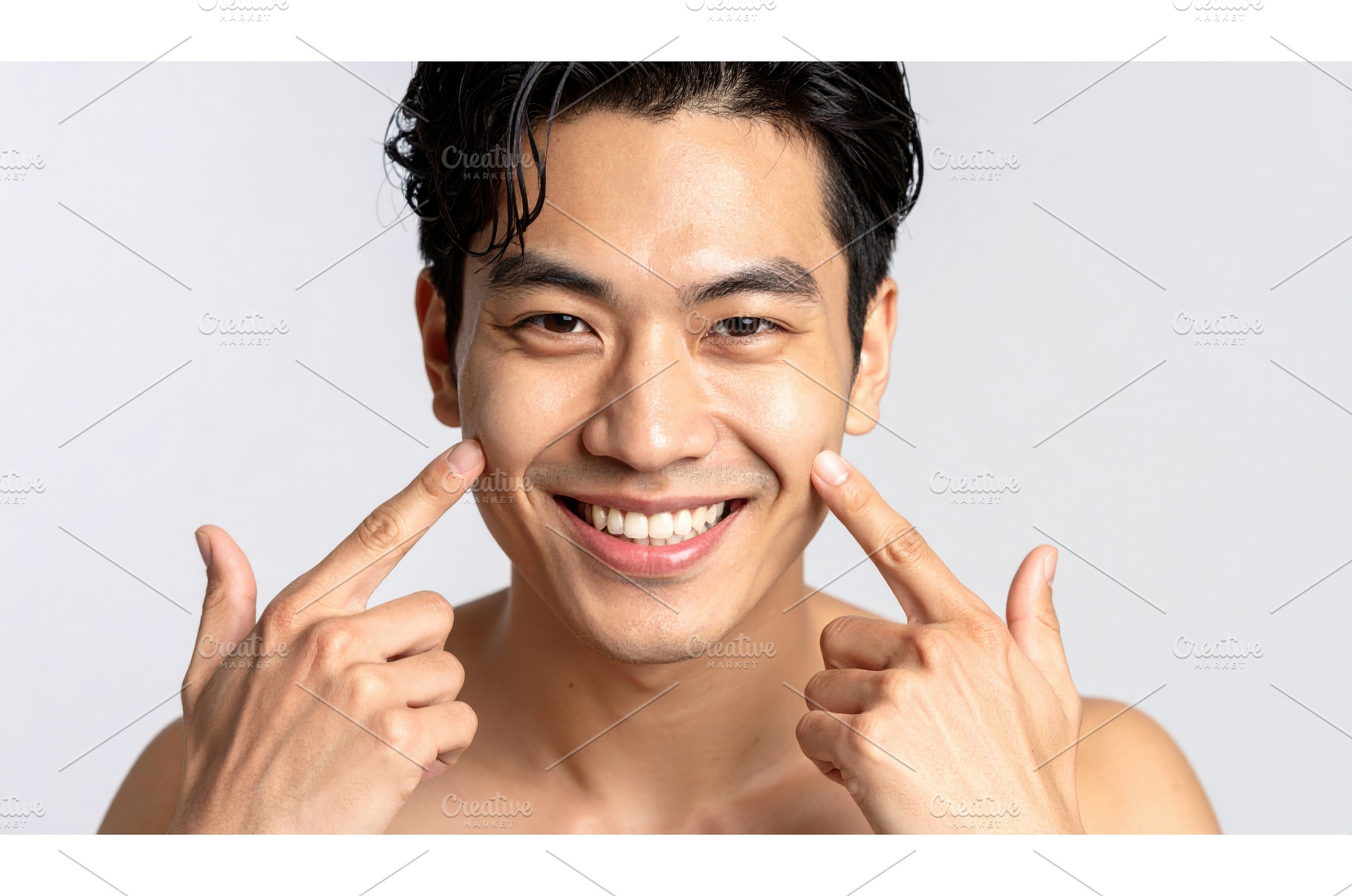 Smiling man pointing to his cheeks, a Person Photo by Igor Tichonow