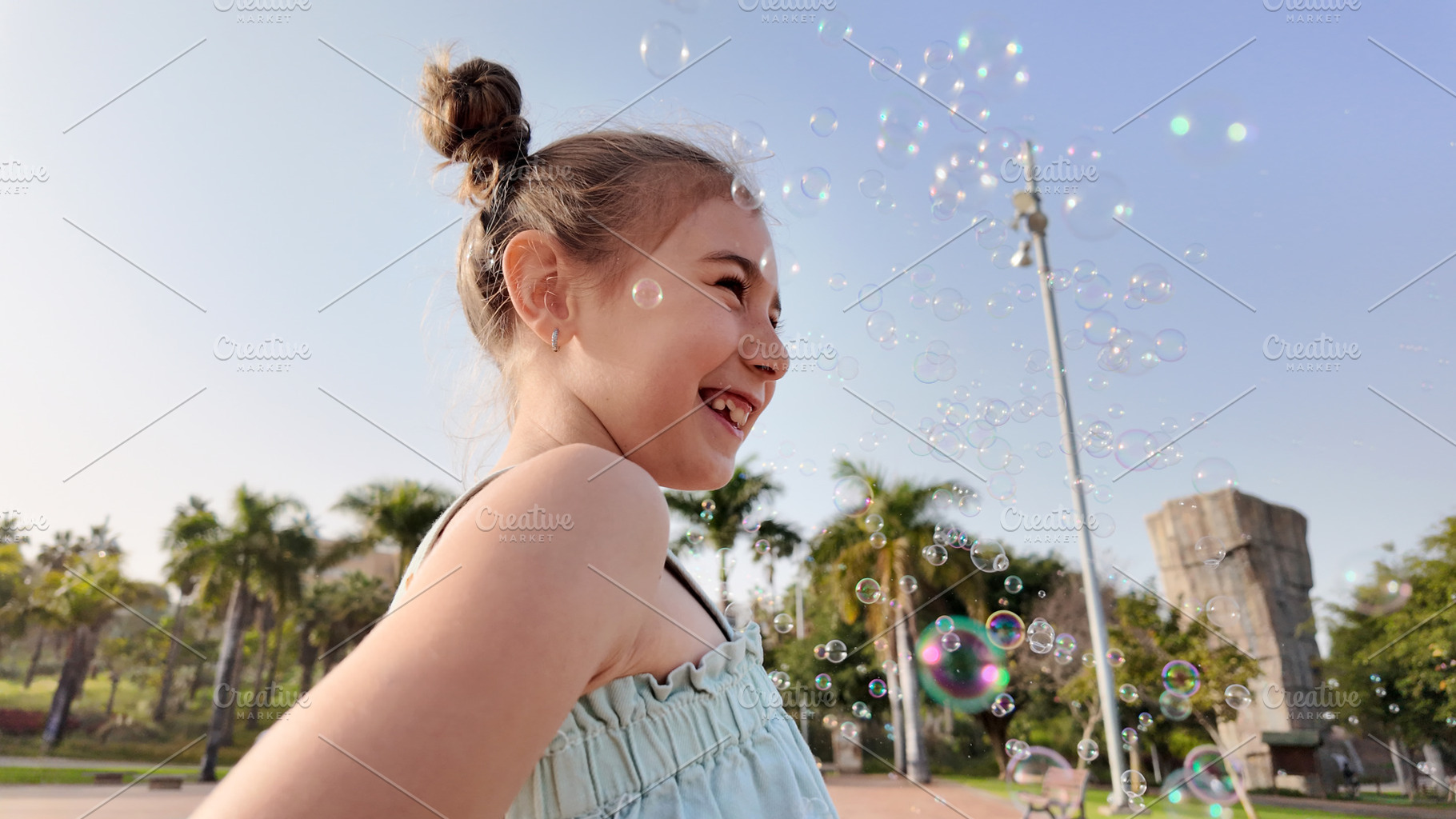 Little Girl Playing with Soap Bubbles in Golden Sunlight, a Person Photo by etorres69