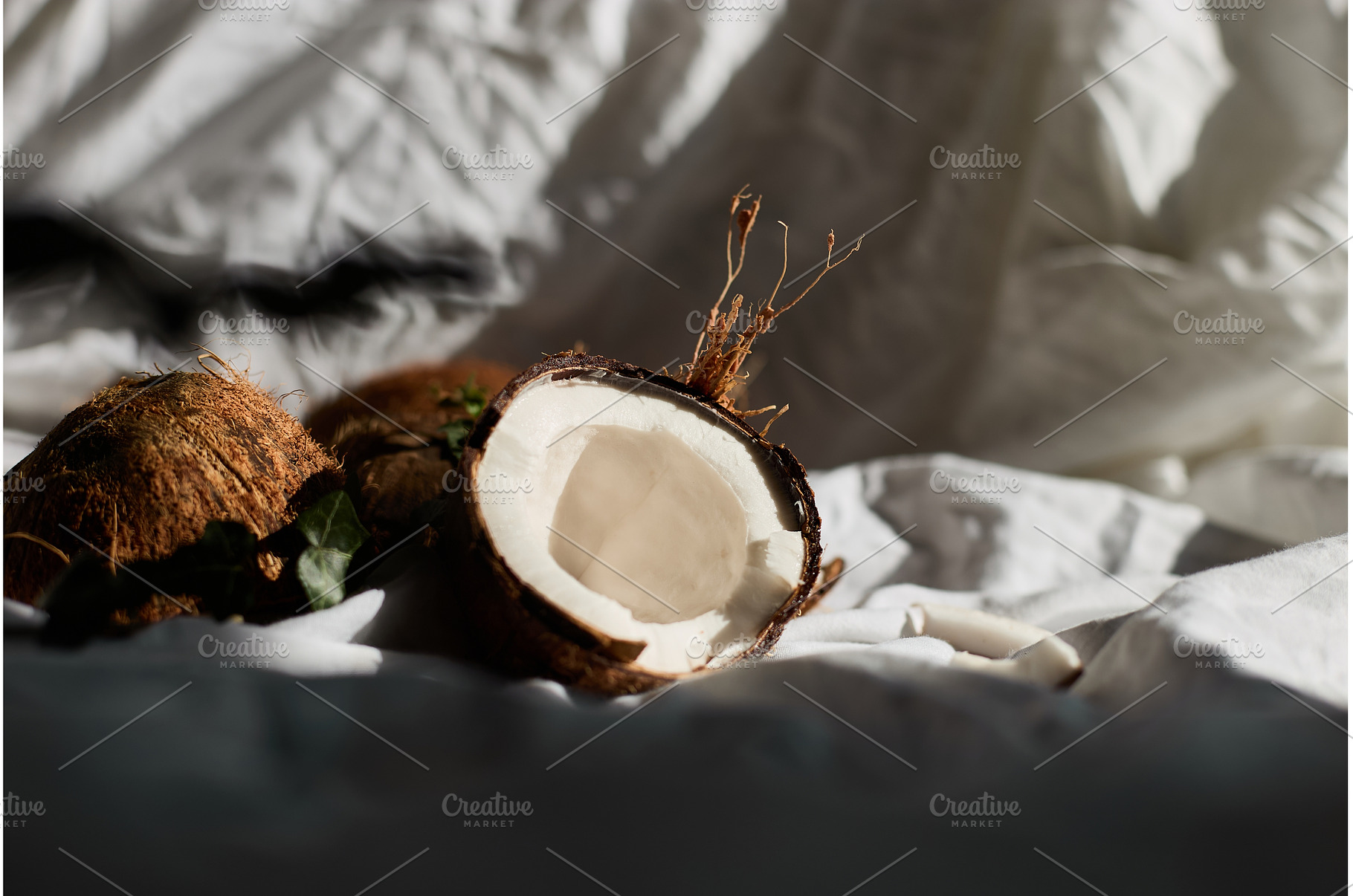 Fresh coconuts on a white cloth with, a Food & Drink Photo by IlliaBondarPhotography