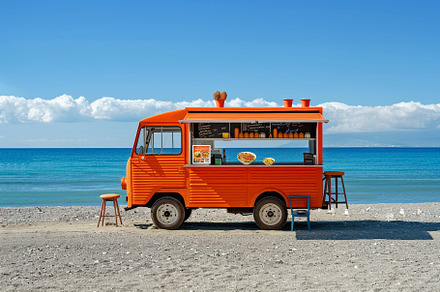 A colorful food truck stands on the, a Photo by Tanuart
