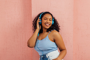 Young cheerful woman enjoying music, a Person Photo by Artem Varnitsin