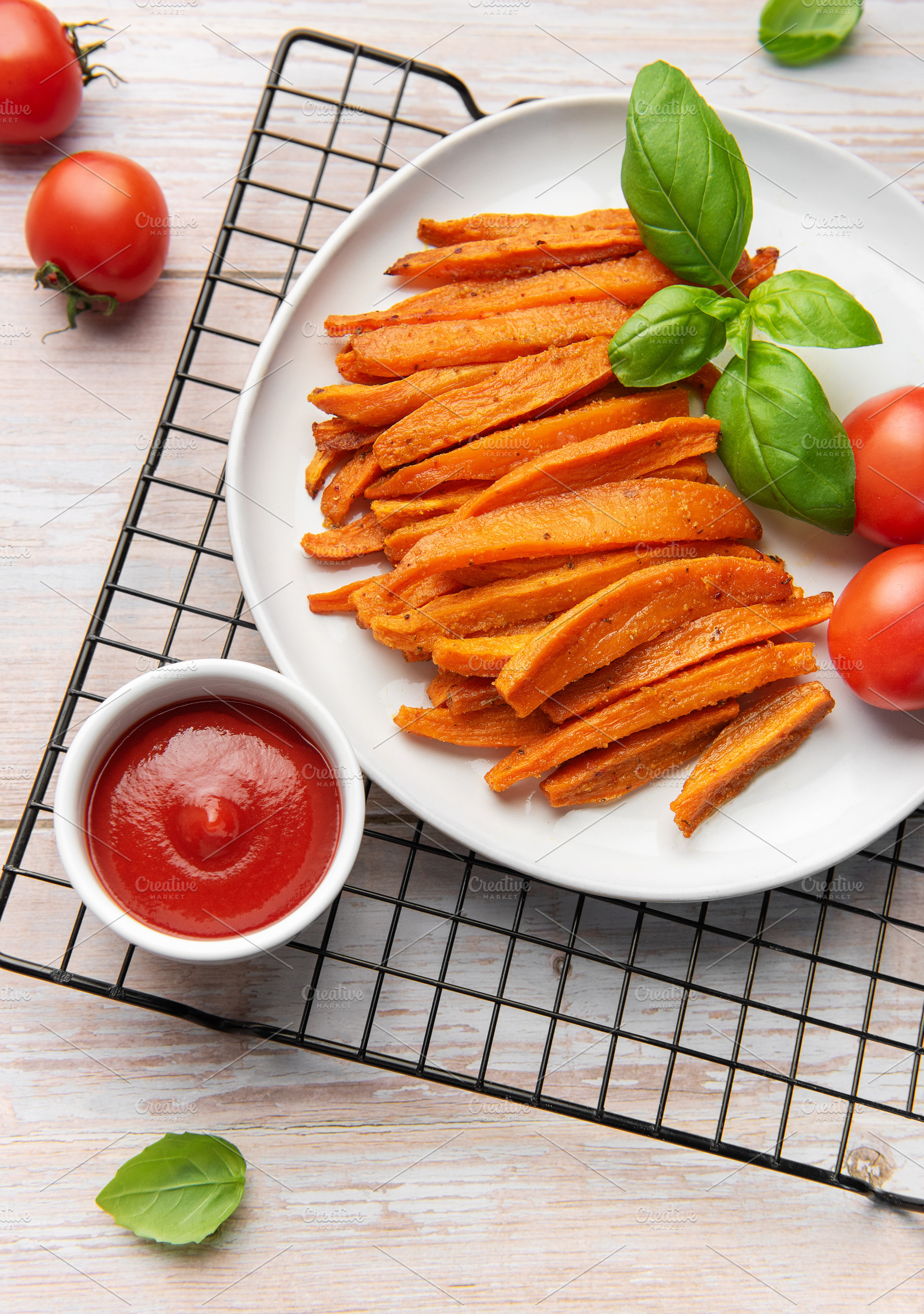 Sweet potato fries with ketchup and fresh basil, a Food & Drink Photo by Olena Rudo