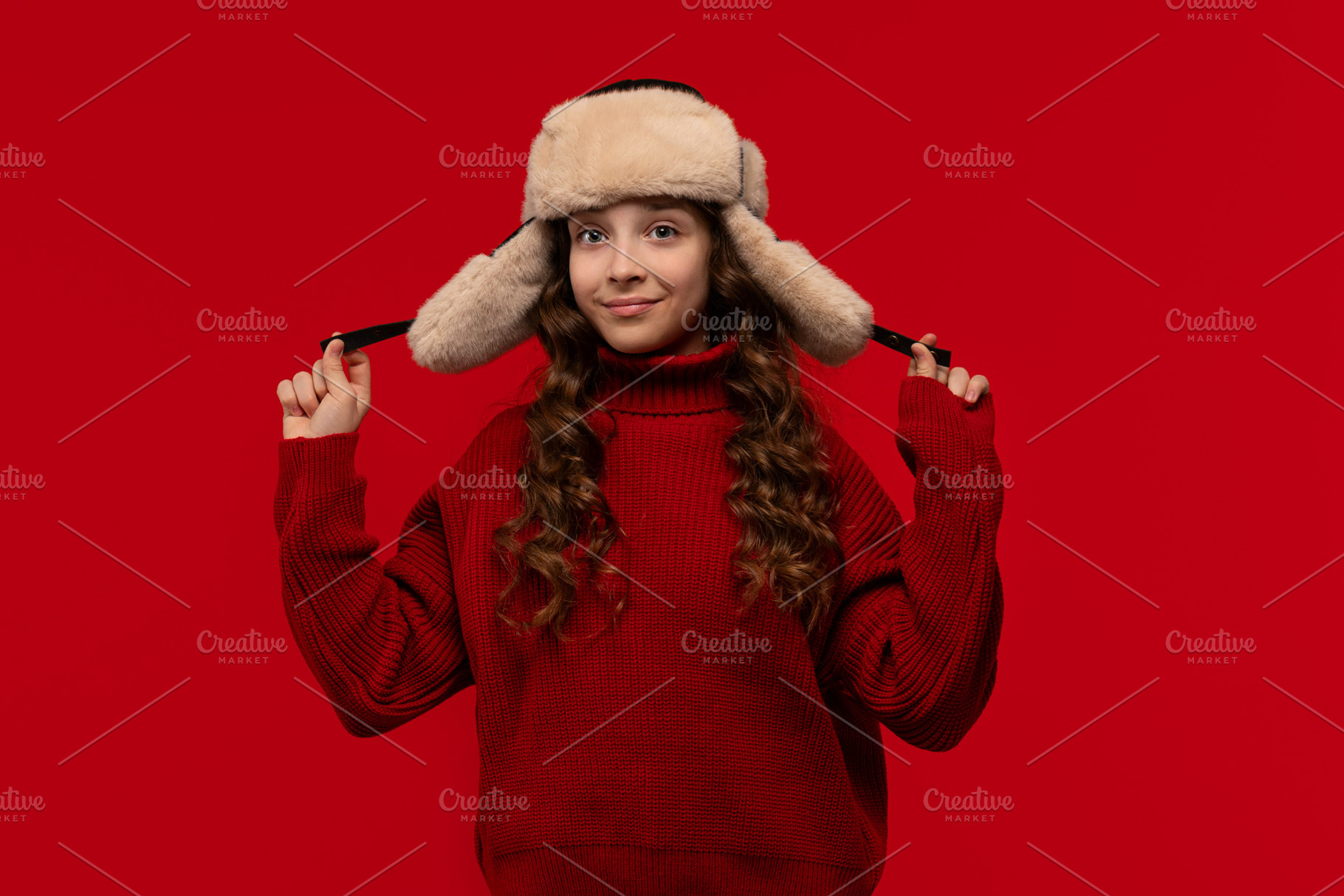Smiling girl in fur hat holds ear, a Person Photo by Elena Vagengeim
