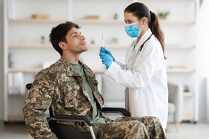 Doctor taking sample for PCR test from disabled soldier, a Photo by Prostock-Studio