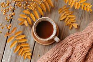 Cozy cup of coffee surrounded by autumn leaves on a wooden table setting, a Food & Drink Photo by AlyaAnd